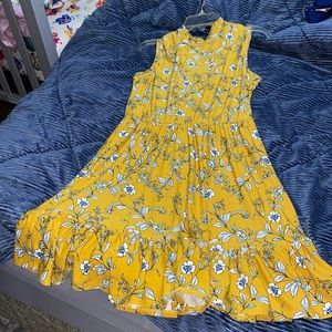 Yellow flowered sleeveless dress.  Sets at the knee. Stretch waisted
